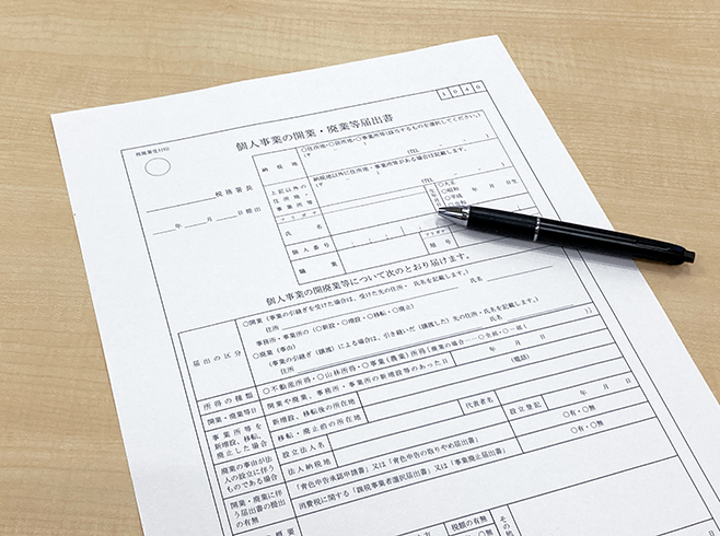 開業届出書とペンで店舗開業手続き準備を表した画像